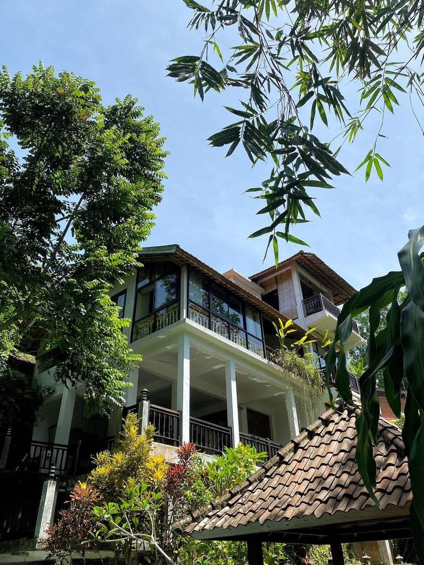 Fachada de la villa de cuatro pisos entre árboles